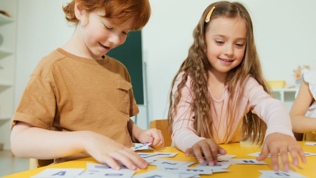 Children learning to read with letter cards